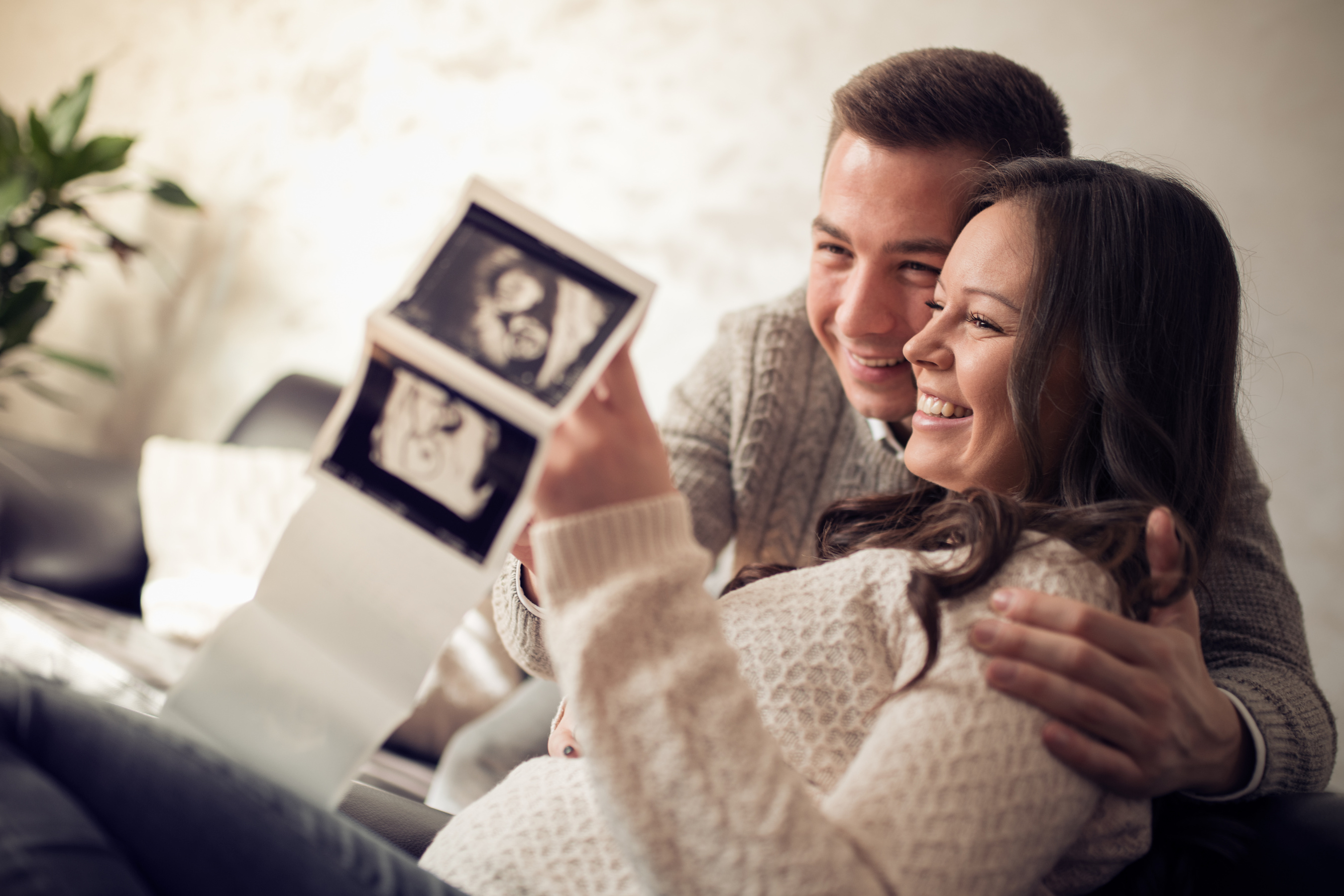 Young pregnant couple looking at ultrasound image